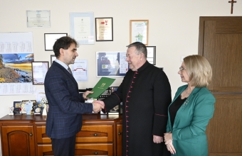 dwoje mężczyzn podaje sobie ręce i kobieta