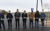 Grupa osób przecinająca wstęgę na drodze