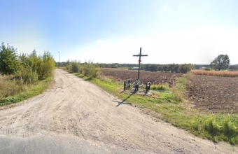 droga zwirowa wsrod pol. Obok drogi krzyz