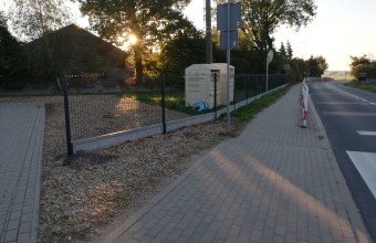 widok na ogrodzenie z siatki obok chodnik i droga