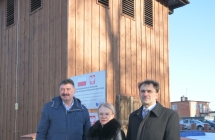 grupa osob na tle zabytkowej dzwonnicy