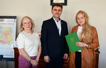 trzy stojace osoby, mezczyzna w srodku po bokach kobiety