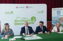 4 osoby siedza przy stoliku z zielonym obrusem