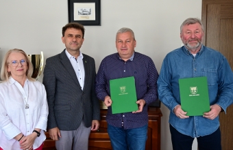 grupa osob, 1 kobieta i 3 mezczyzn, 2 trzyma zielone teczki