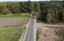 droga asfaltowa biegnąca wśród pól i lasu